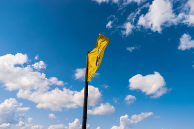 Low angle view of flag against blue sky