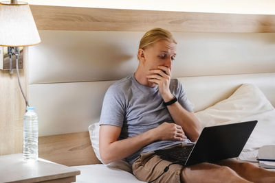 Young woman using laptop while sitting at home