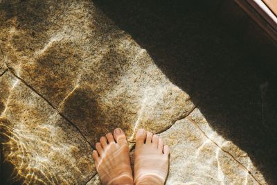 Low section of person standing on tiled floor