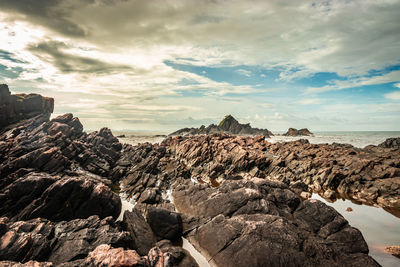 Rocks on beach against sky