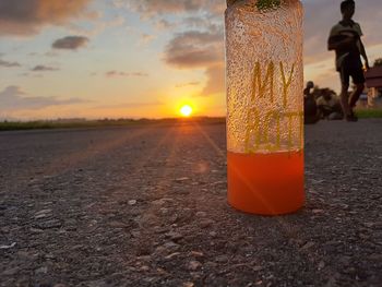 Close-up of drink at street during sunset