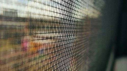 Close-up of metal grate against sky