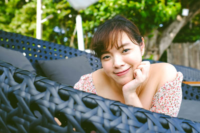 Portrait of smiling young woman sitting outdoors