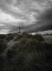 Lighthouse on field against sky