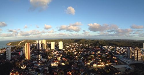 High angle view of illuminated city against cloudy sky