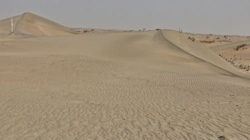 Sand dunes in desert against sky