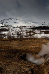 Smoke emerging from volcanic landscape