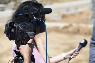 Cropped hand of cameraman filming interview