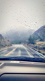 Cars on road seen through wet window