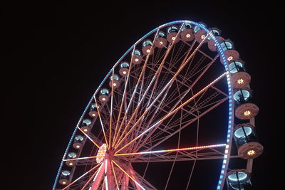 Low angle view of illuminated ferris wheel against sky at night