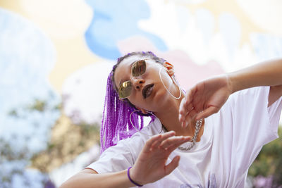 Portrait of woman with dyed hair dancing outdoors