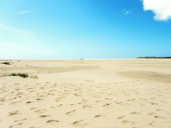 Scenic view of sand dunes against clear blue sky