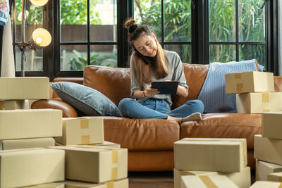 Portrait of young woman sitting on sofa at home