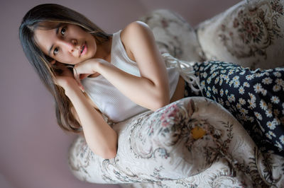 Portrait of young woman sitting on bed