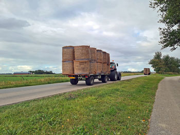 Tractors with harvested hay bales on the road in friesland the netherlands