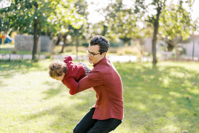 Side view of boy playing with dog