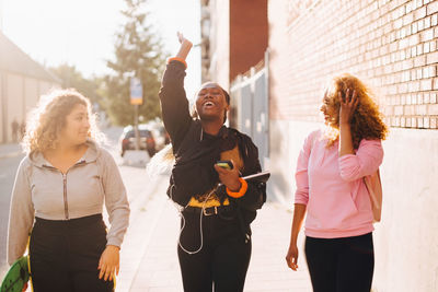 Women standing against people in city