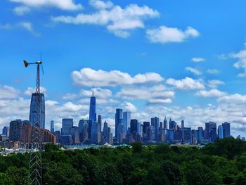 View of buildings in city against cloudy sky