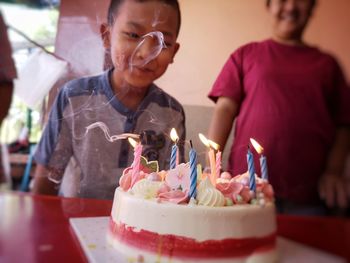 Close-up of cake with smiling boy in background