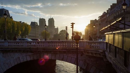 Silhouette of bridge over river in city