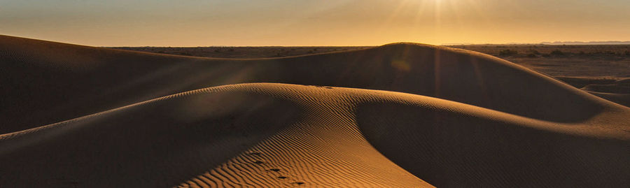 Scenic view of desert against sky during sunset