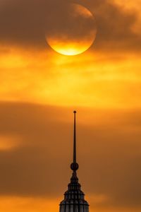 Silhouette of building against cloudy sky during sunset