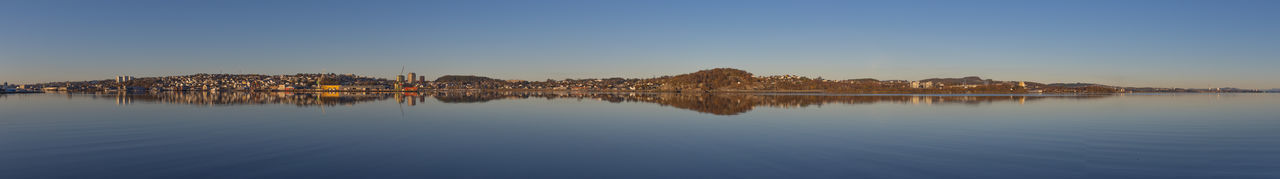 Panoramic view of lake against clear blue sky