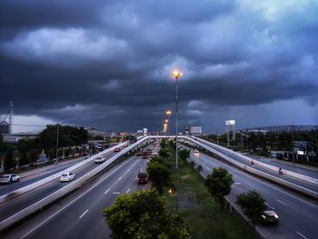 Cars on road against sky in city