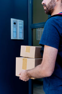 Midsection of delivery person holding parcel