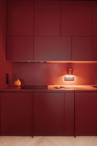 Orange cabinetry paired with wood countertops in a kitchen with stove top oven