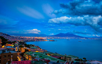 Aerial view of city by sea against sky