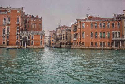 Canal by sea against sky in city