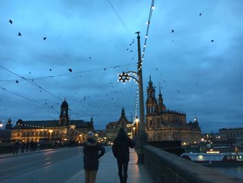 Buildings in city against cloudy sky