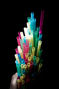 Close-up of hand holding multi colored lights against black background