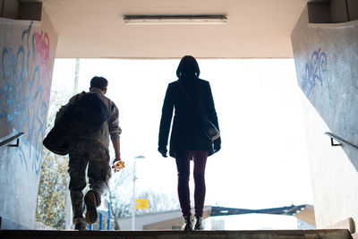 Rear view of man and woman walking on steps