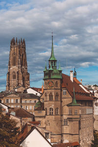 Buildings in city against cloudy sky