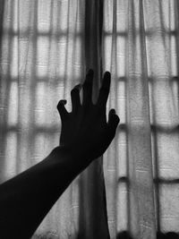 Shadow of person hand on curtain