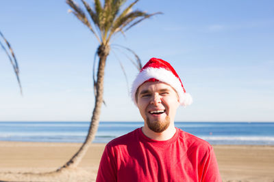 Portrait of mature man on beach against sky