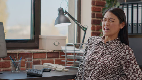 Portrait of young woman standing in office