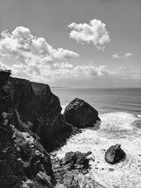 Rocks on sea shore against sky