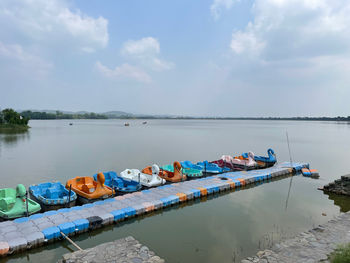 Boats moored in lake against sky