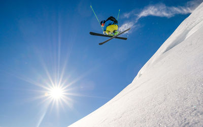 Man skiing on snowcapped mountain against sky