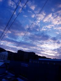 Electricity pylon in city against sky