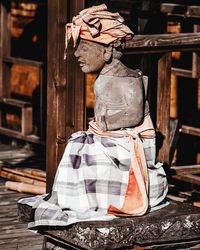 Rear view of woman against wooden wall