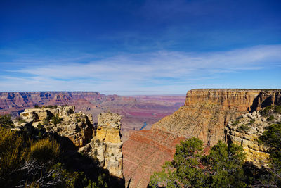 Rock formations on landscape against blue sky