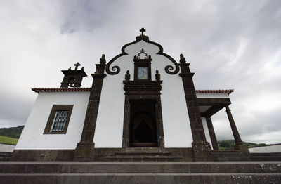 Low angle view of cross on building against sky