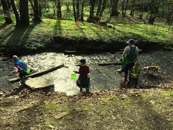 People standing on field in forest