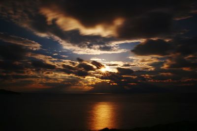 Scenic view of sea against dramatic sky during sunset