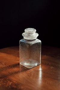 Close-up of wineglass on table against black background