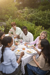Portrait of smiling friends sitting on table